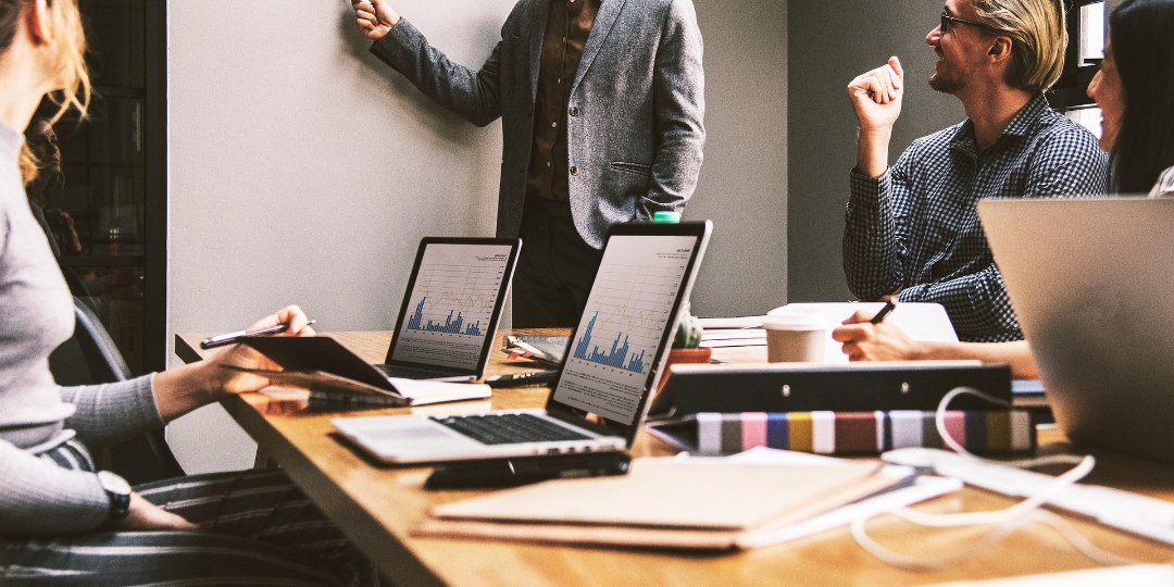 Erfolgreiche Vertriebsleiter brauchen klare Strategien, Führungskompetenz und die Fähigkeit, Teams nachhaltig zu motivieren. Die fünf unverzichtbaren Disziplinen – von Zielmanagement über Kommunikation bis hin zu Datenanalyse – bilden die Grundlage für Wachstum und langfristigen Vertriebserfolg. Bildbeschreibung: Mehrere Personen sitzen an einem Konferenztisch mit Laptops und Notizen, während eine Person im Anzug vor einer Wand steht und etwas präsentiert. Auf den Bildschirmen sind Diagramme und Statistiken zu sehen.